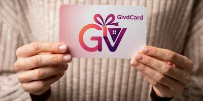 Person holding a GivdCard gift card with both hands, showing the branded card with gift ribbon logo