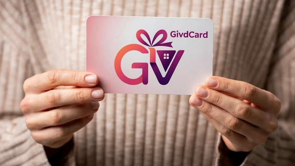 Person holding a GivdCard gift card with both hands, showing the branded card with gift ribbon logo